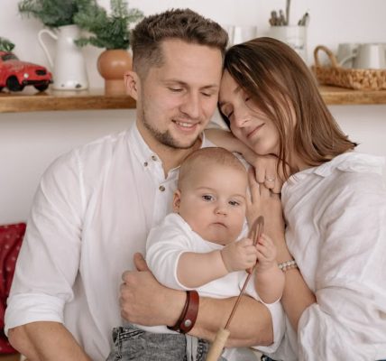 A joyful family of three embracing in a cozy kitchen. Warm and loving atmosphere.